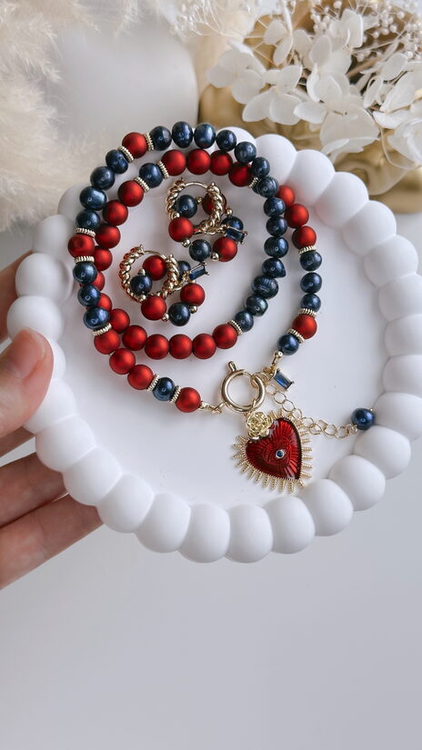 Komplekts ar tumši zilām saldūdens pērlēm un sarkaniem akcentiem.