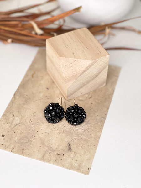 Melni podziņu auskari uz āķīša